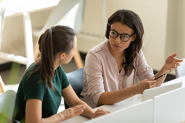 Two young female employees talking