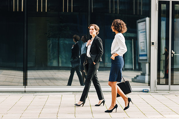 Two women co workers walk to the office together