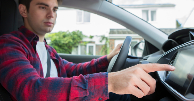 Male Driver Using Touchscreen In Company Car