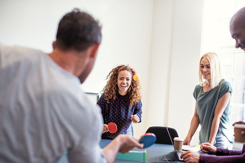 people competing at ping pong in an office