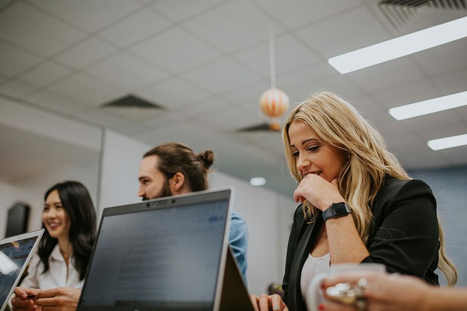 Trusting employees smiling together at a team meeting.