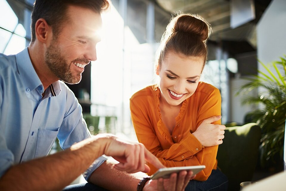 Employees sitting together at work and smiling in the bright office.