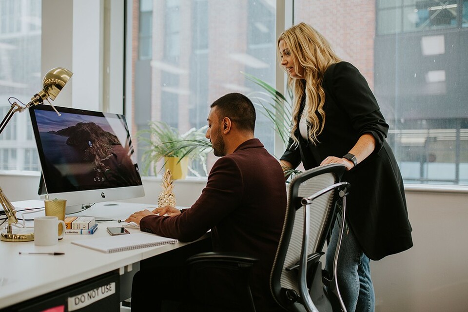A supportive team leader helping an employee with a task