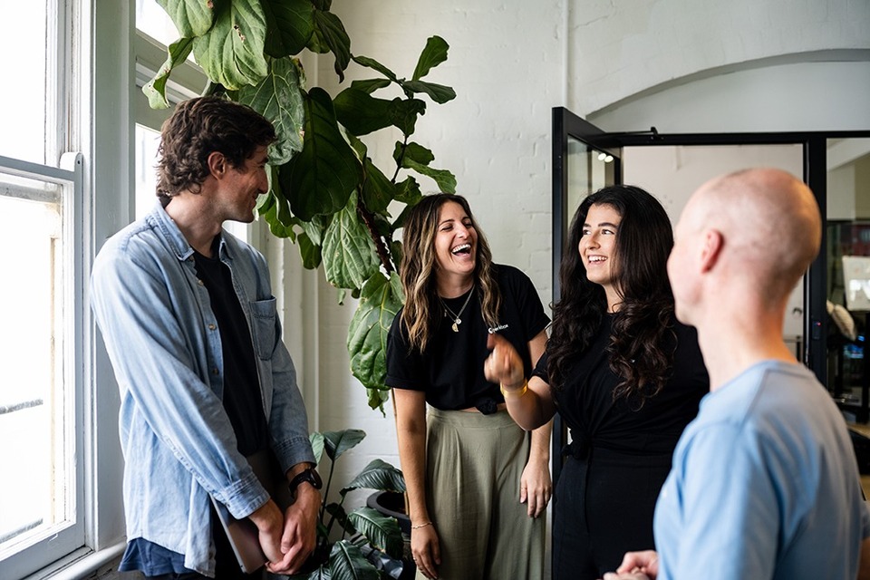 An engaged team smiling and laughing at an informal meeting