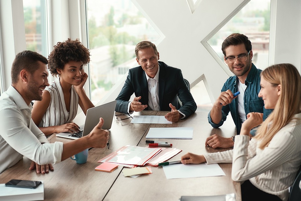 Employees smiling at a team meeting as part of a positive company culture