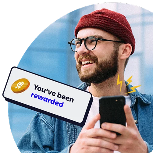 Smiling man holding a smartphone with a pop-up message that says “You’ve been rewarded,” representing employee recognition.