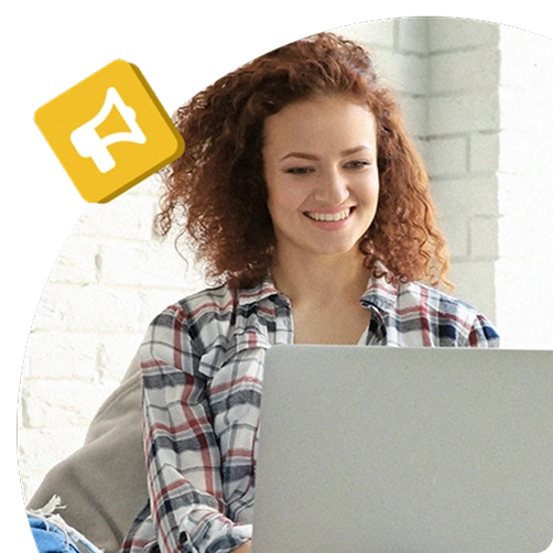 Smiling employee using a laptop at home, with a megaphone icon symbolising digital communication or company announcements.