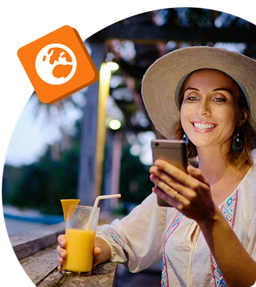 Smiling person in holiday attire checking her phone at a tropical bar, enjoying a juice drink—symbolising remote recognition or rewards on the go.