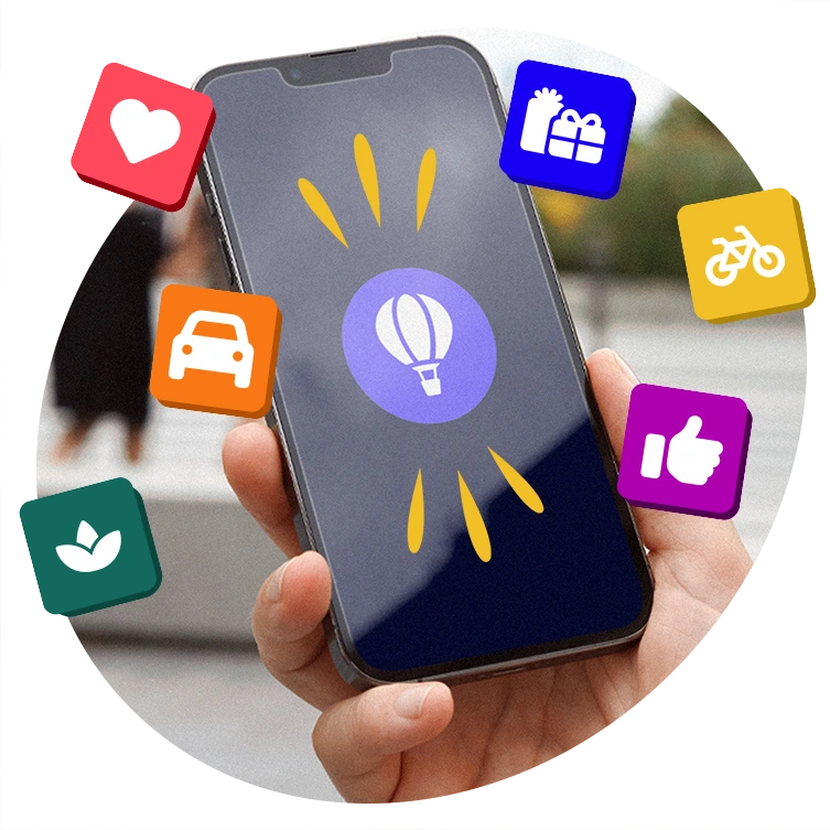 Close-up of a hand holding a smartphone displaying a hot air balloon icon, surrounded by colourful icons including a heart, car, gift, bike, thumbs up, and a plant symbol.