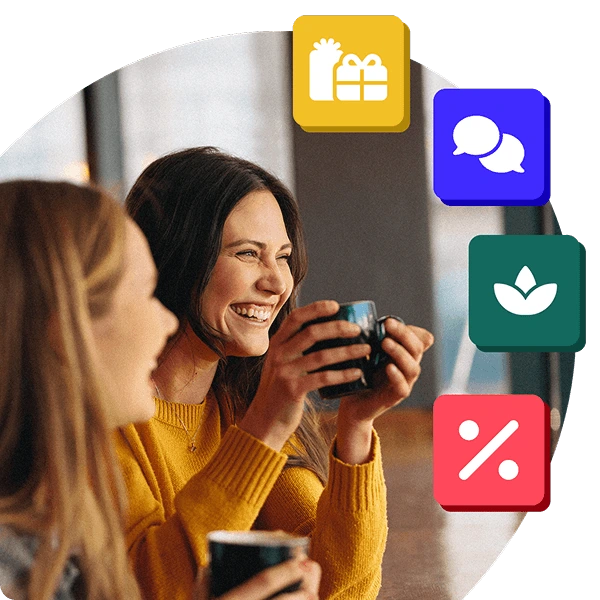 Two smiling colleagues enjoy a coffee break, surrounded by icons representing rewards, wellbeing, savings, and communication through Perkbox.