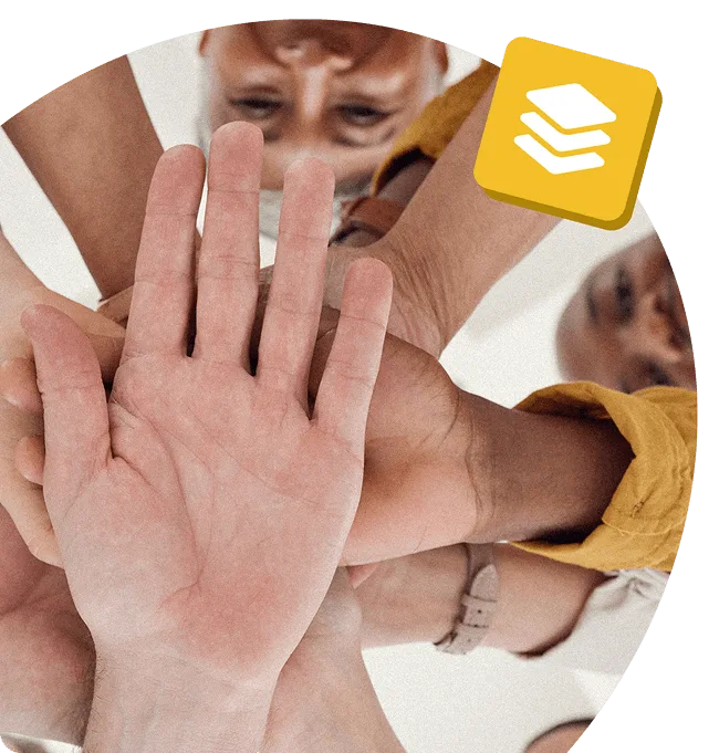 Group of diverse teammates stacking hands in unity, viewed from below, symbolising collaboration and shared purpose.