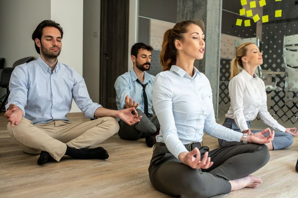 people meditating in office